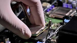 Mão de PC Builder com luva inserindo processador na placa mãe